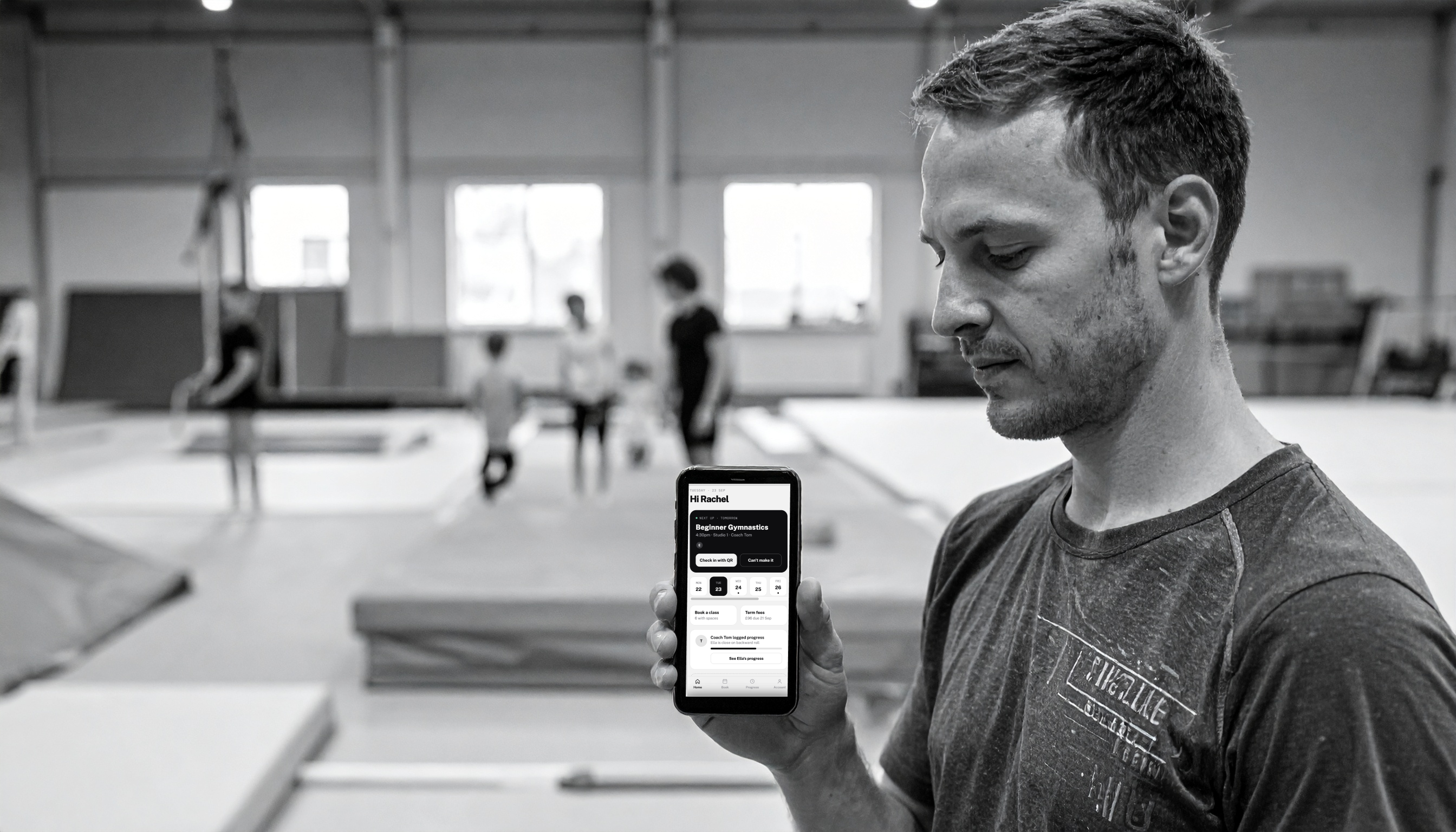 A gymnastics coach checking the AnyClub class register on her phone.